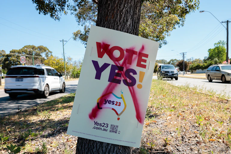 Vandalised vote yes corflute attached to a tree