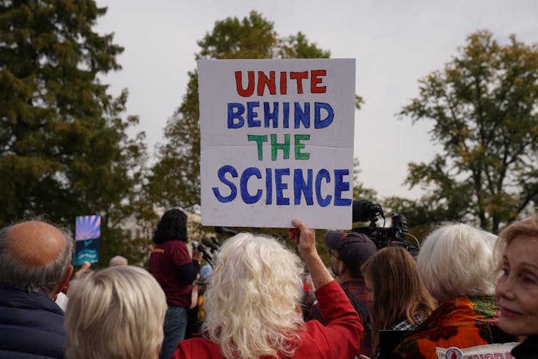 sign saying unite behind climate science