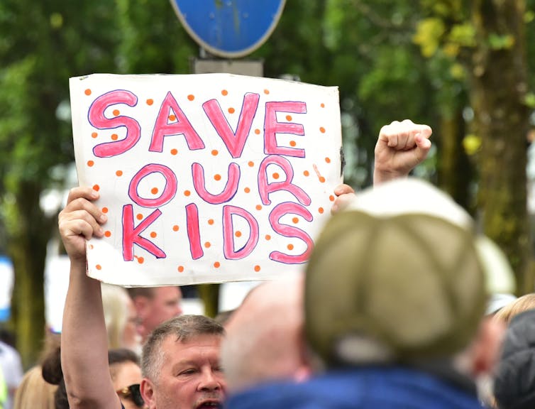 Um homem segurando um cartaz