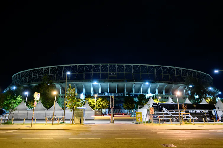A side view of a stadium at night time.