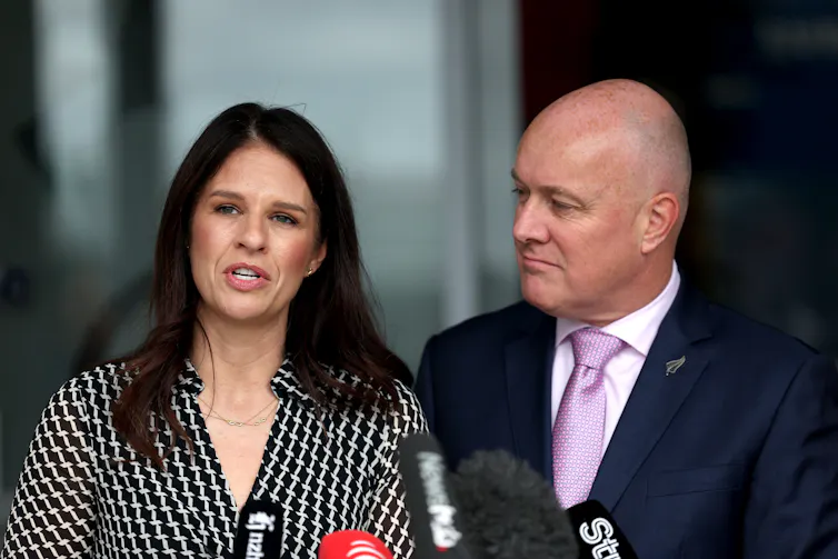 New Zealand Prime Minister Christopher Luxon (R) and Education Minister Erica Stanford (L) speak to media