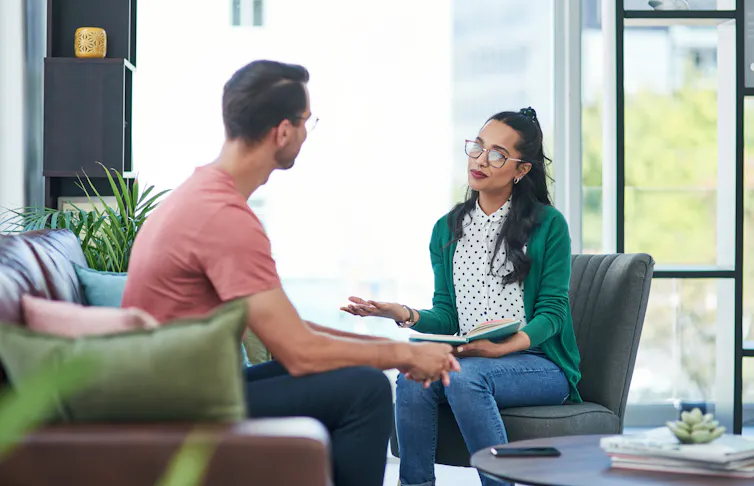 A young man talking to a young female therapist.