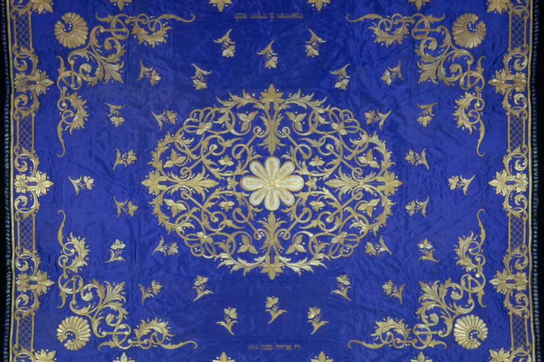 An intricate gold design on a purple-blue fabric.
