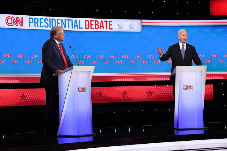 Biden and Trump stand at lecterns on a debate stage.