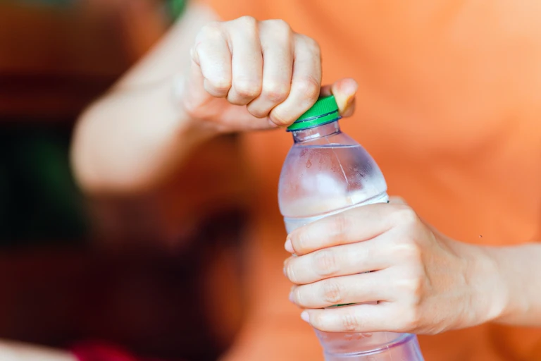 Woman opening plastic water bottle