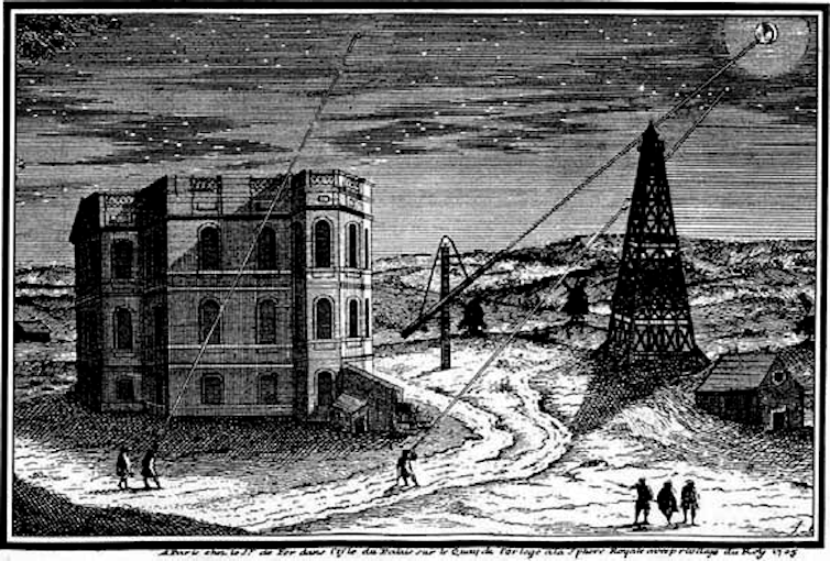 Black and white engraving of a three storey building beside a tower under a starry sky