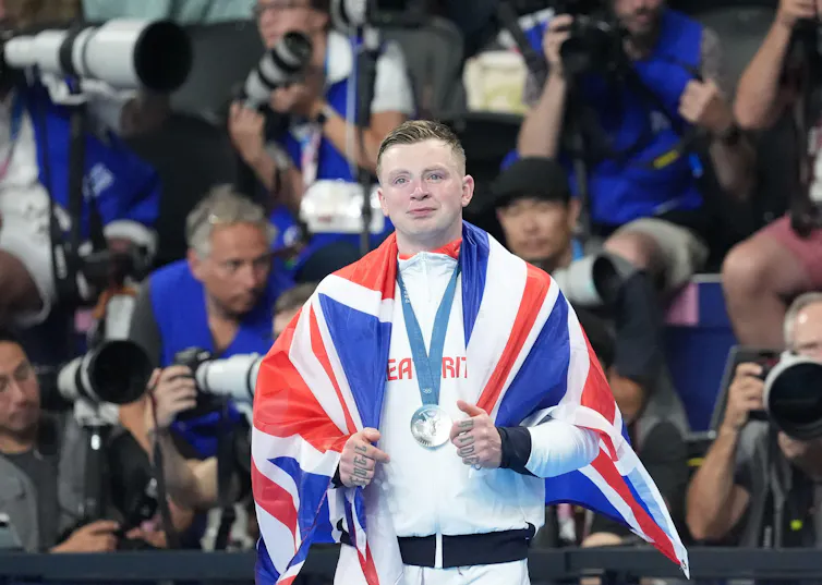 A British Olympic athlete draped in the Union Jack celebrating his silver medal.