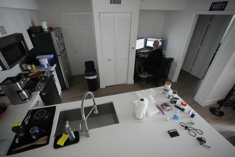 A man sits at a desk working at a computer.