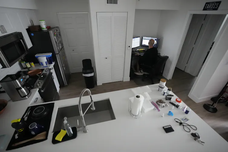 A man sits at a desk working at a computer.