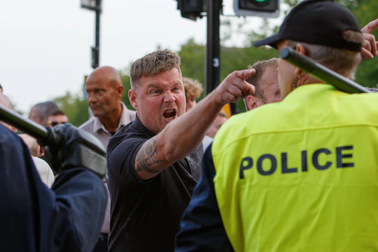 A man points and screams at a police officer.