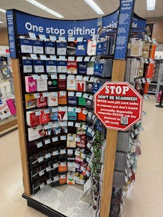 Gift card kiosk with a stop sign shaped warning sign