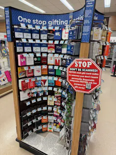 Gift card kiosk with a stop sign shaped warning sign