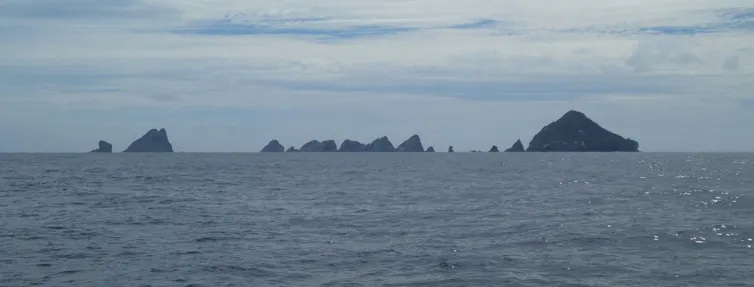 The Three Kings Islands/Manawatāwhi, a rugged island chain to the north of New Zealand, viewed from the sea.