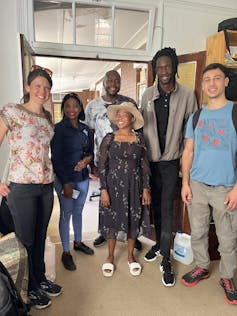 6 smiling researchers stand in a room before setting off for a rural area to see how they can protect water supplies.