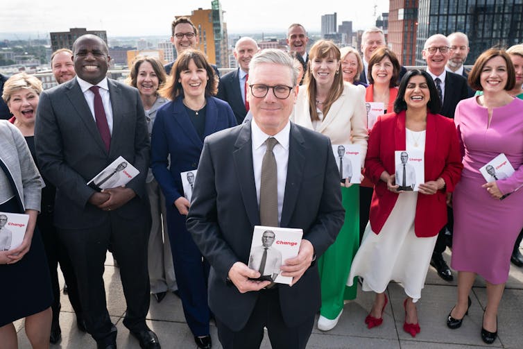Keir Starmer and his top team holding copies of the 2024 Labour manifesto.