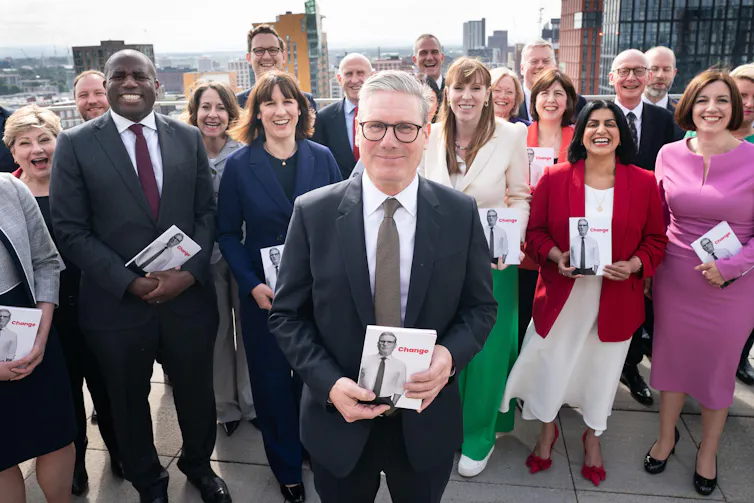 Keir Starmer and his top team holding copies of the 2024 Labour manifesto.