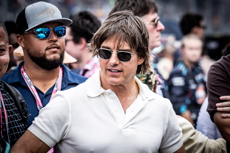 L'acteur Tom Cruise et un autre homme au second plan portent des lunettes de soleil.