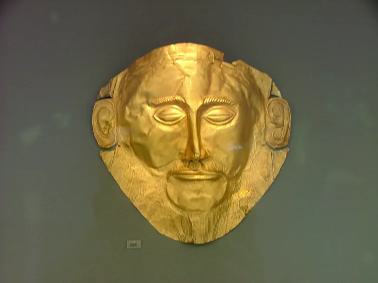 A gold mask depicting a bearded man.