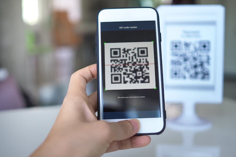 Women's hand uses a mobile phone application to scan QR codes in store