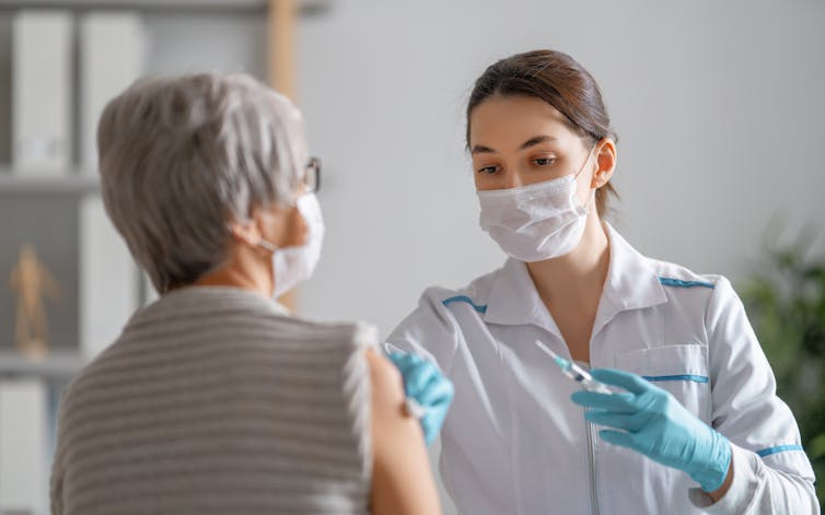 A woman receives a vaccination.