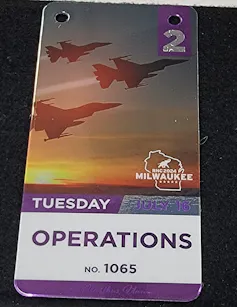A plastic badge with fighter jets pictured and the words 'Tuesday' and 'Operations' on it.