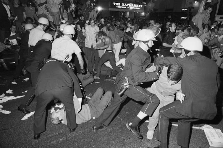 Police with helmets attacking protesters.