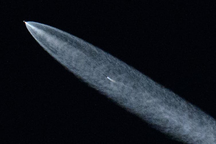 A SpaceX Falcon 9 rocket with a payload of 20 Starlink satellites is seen in the evening sky.