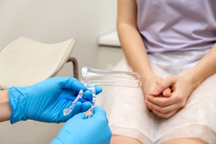 Clinician holds speculum