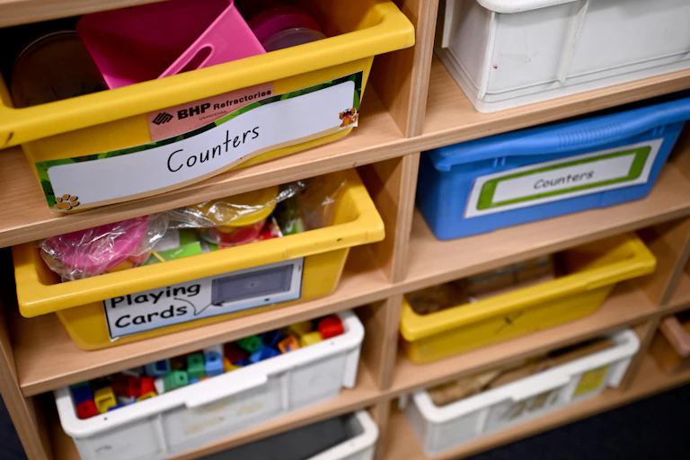 Trays in a book shelf with labels, 'counters' and 'playing cards'.