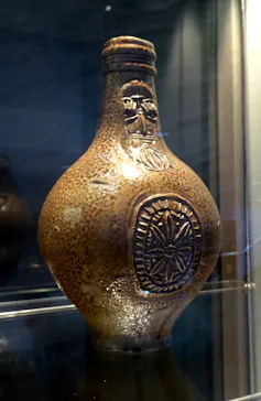 Jarra marrón con el dibujo de un hombre barbudo.