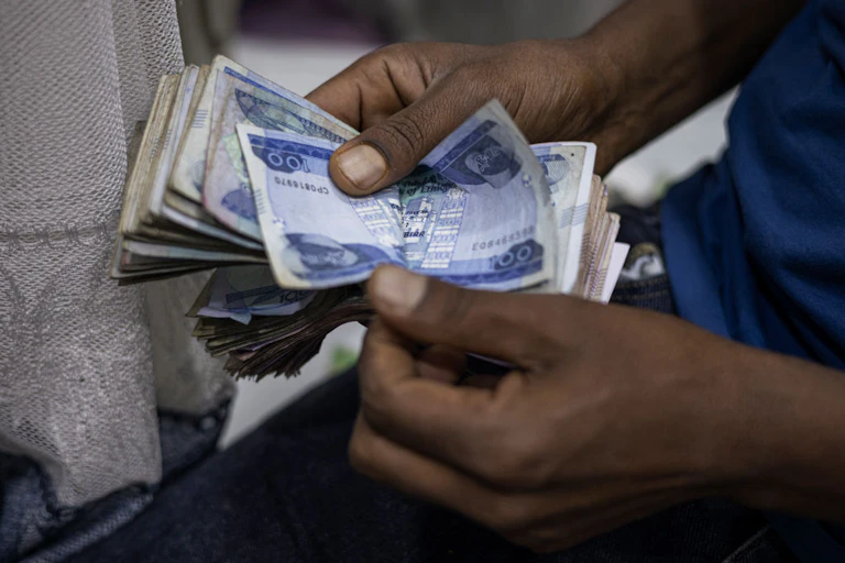Close-up of two hands counting banknotes