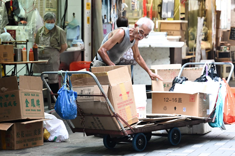 An old man sorts through cardboard boxes