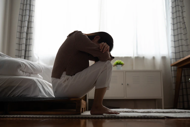 A woman sitting with her head on her knees