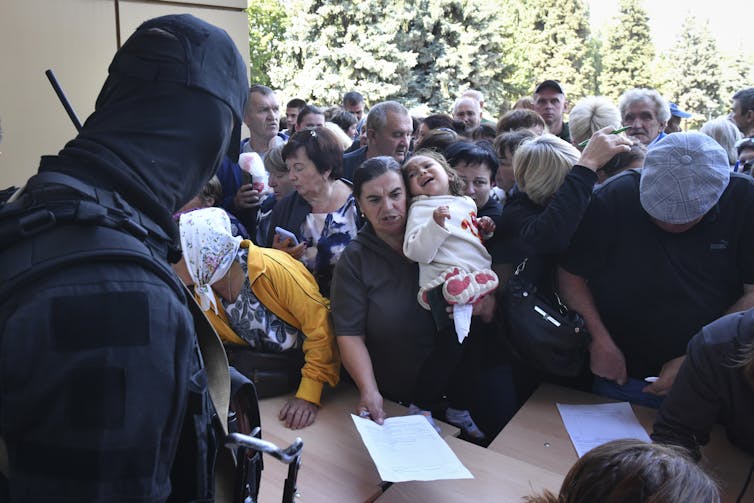 Russian evacuees filling out forms for humanitarian aid.
