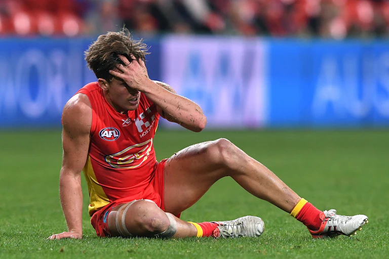 Gold Coast's David Swallow recovers after a head knock