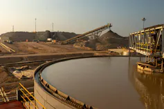 A giant mine with machinery and a large pond