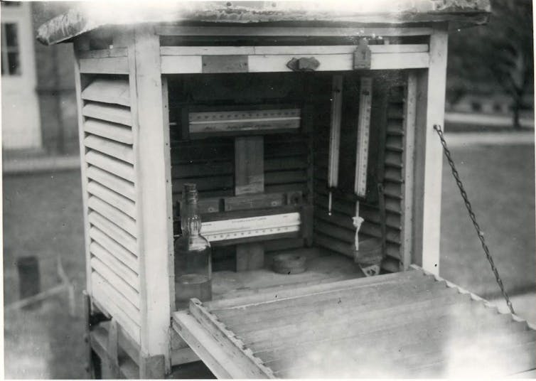 A black-and-white photo of a wooden, slatted box containing scientific instruments.