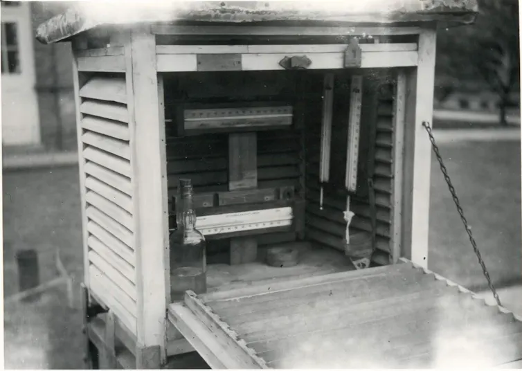 A black-and-white photo of a wooden, slatted box containing scientific instruments.