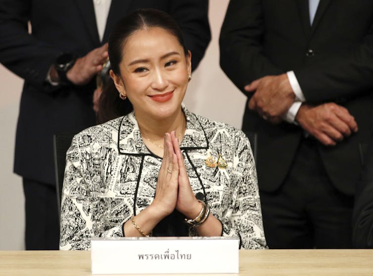 Paetongtarn Shinawatra smiling with her hands clasped together.