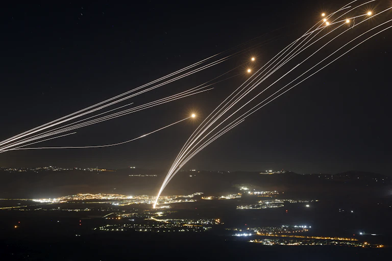Rockets whiz across the nighttime sky