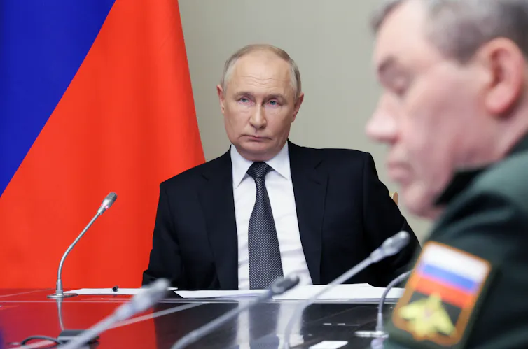 Russian president, Vladimir Putin. sits listening to his advisers, August 13 2024.