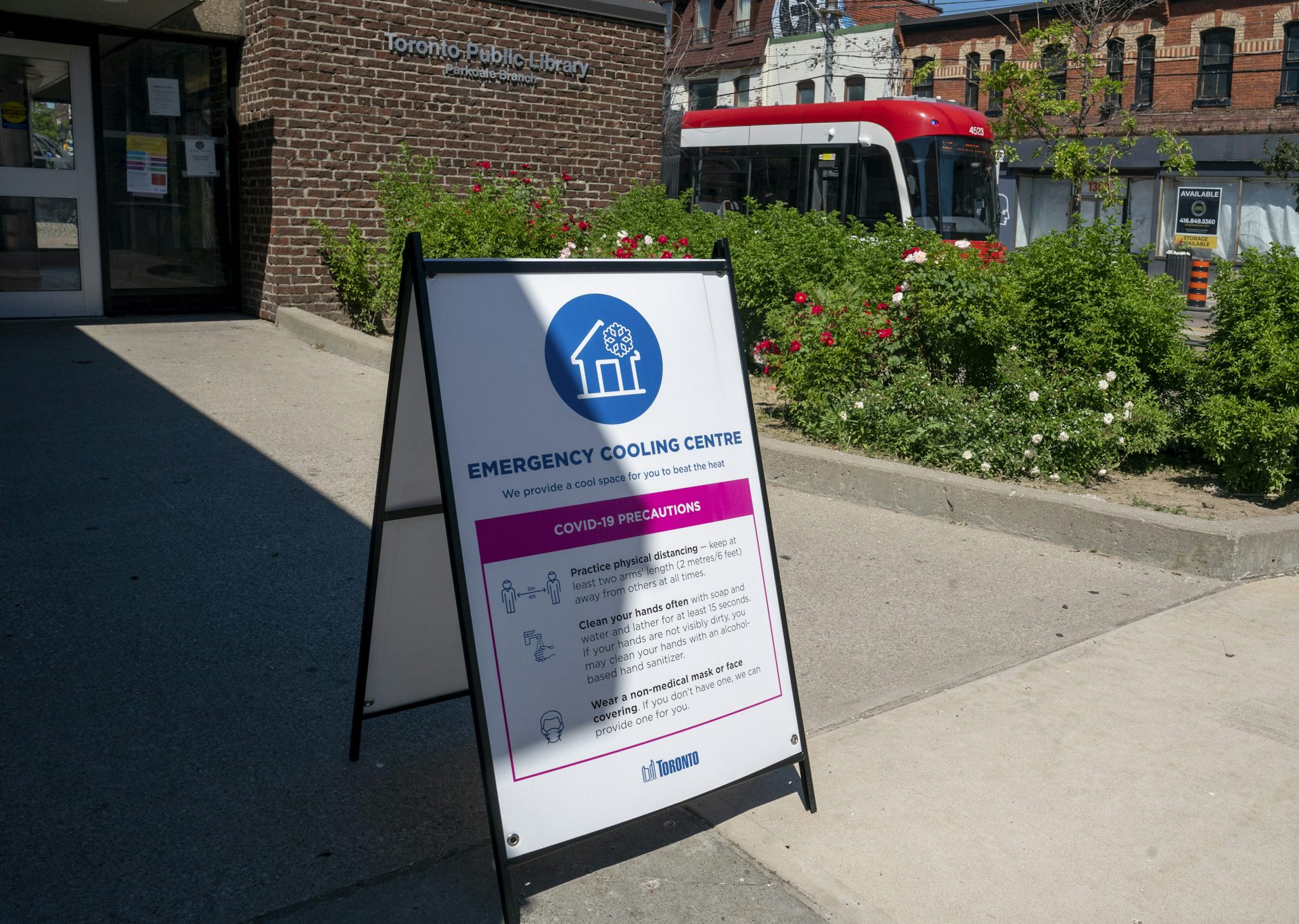 A sign for an emergency cooling centre on a sidewalk