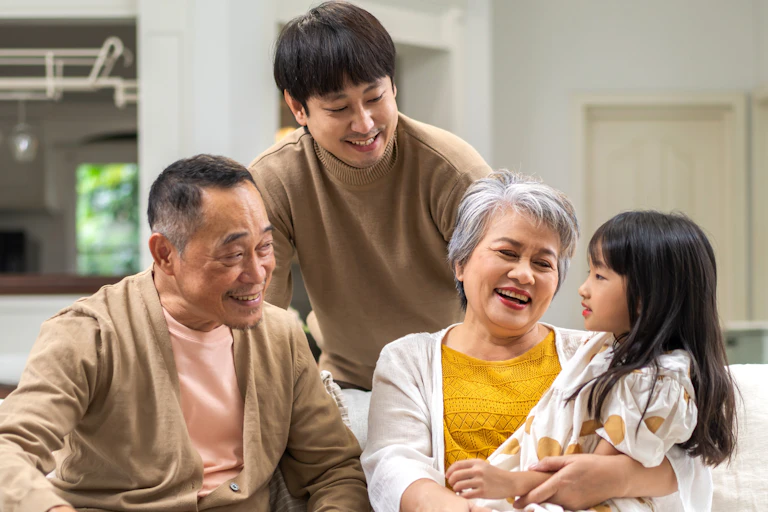 A multigenerational family sits on a couch together