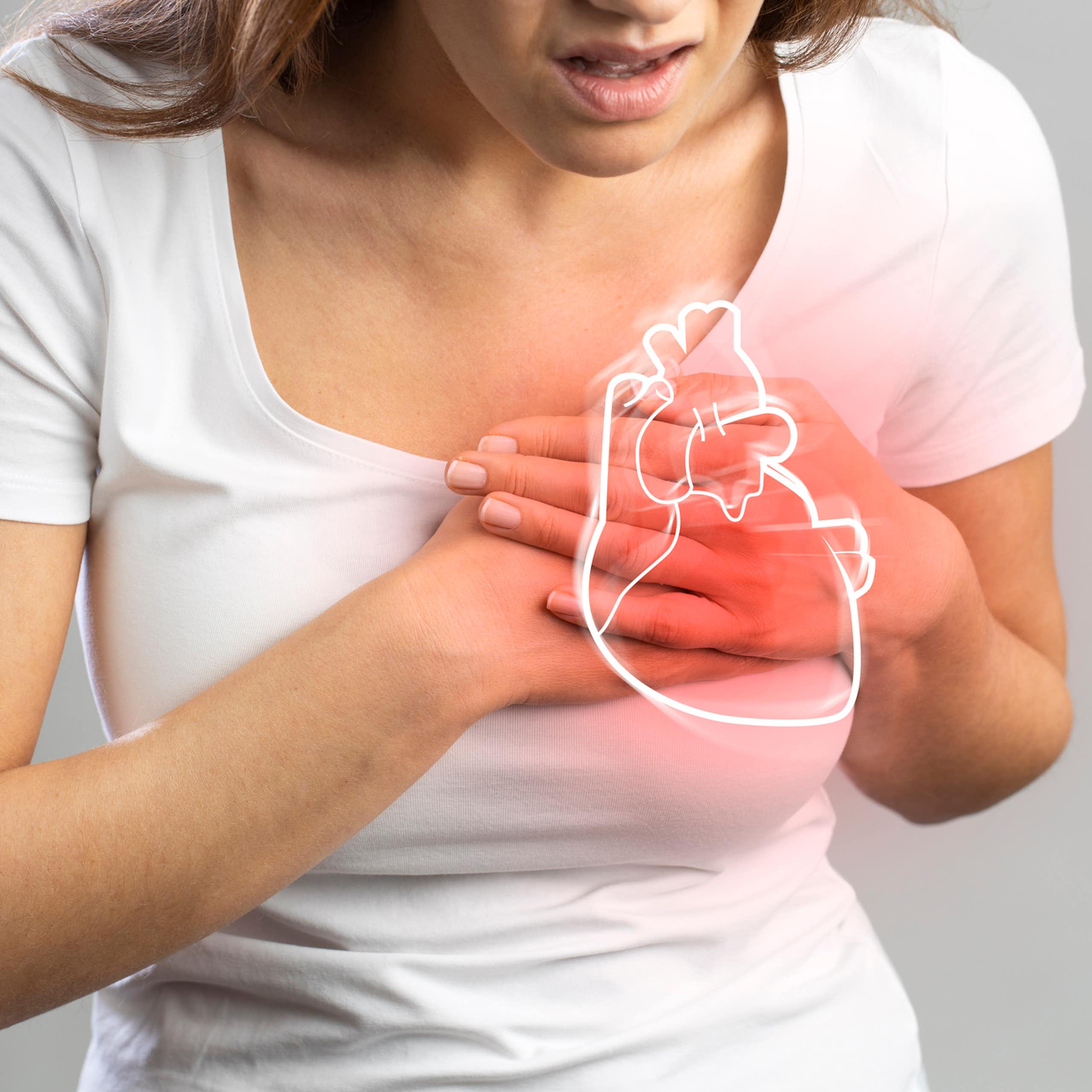 Person with hands over chest in pain, beneath a glowing outline of a heart