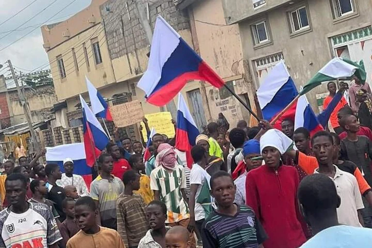 A group of people protesting while holding flags