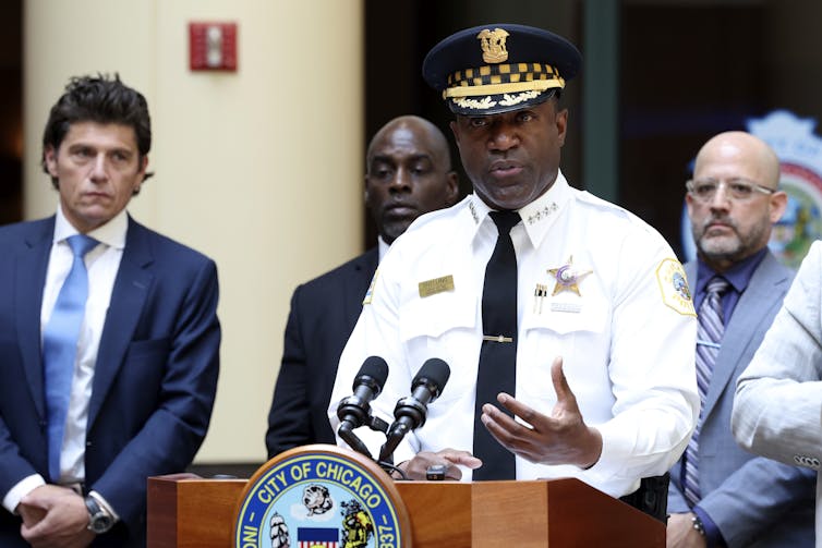 a man in a police uniform speaks at a podium
