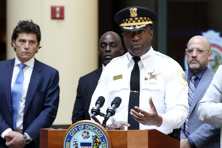 a man in a police uniform speaks at a podium