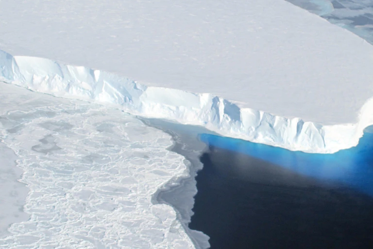 An aerial view of Thwaites ice shelf's front shows an already tall area of floating ice.