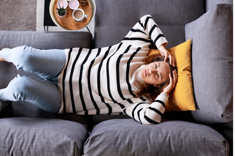A birds eye view of a woman lying on a couch.