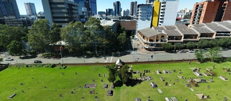 Aerial view of St John's Cemetery, Parramatta, alongside a road and commercial buildings
